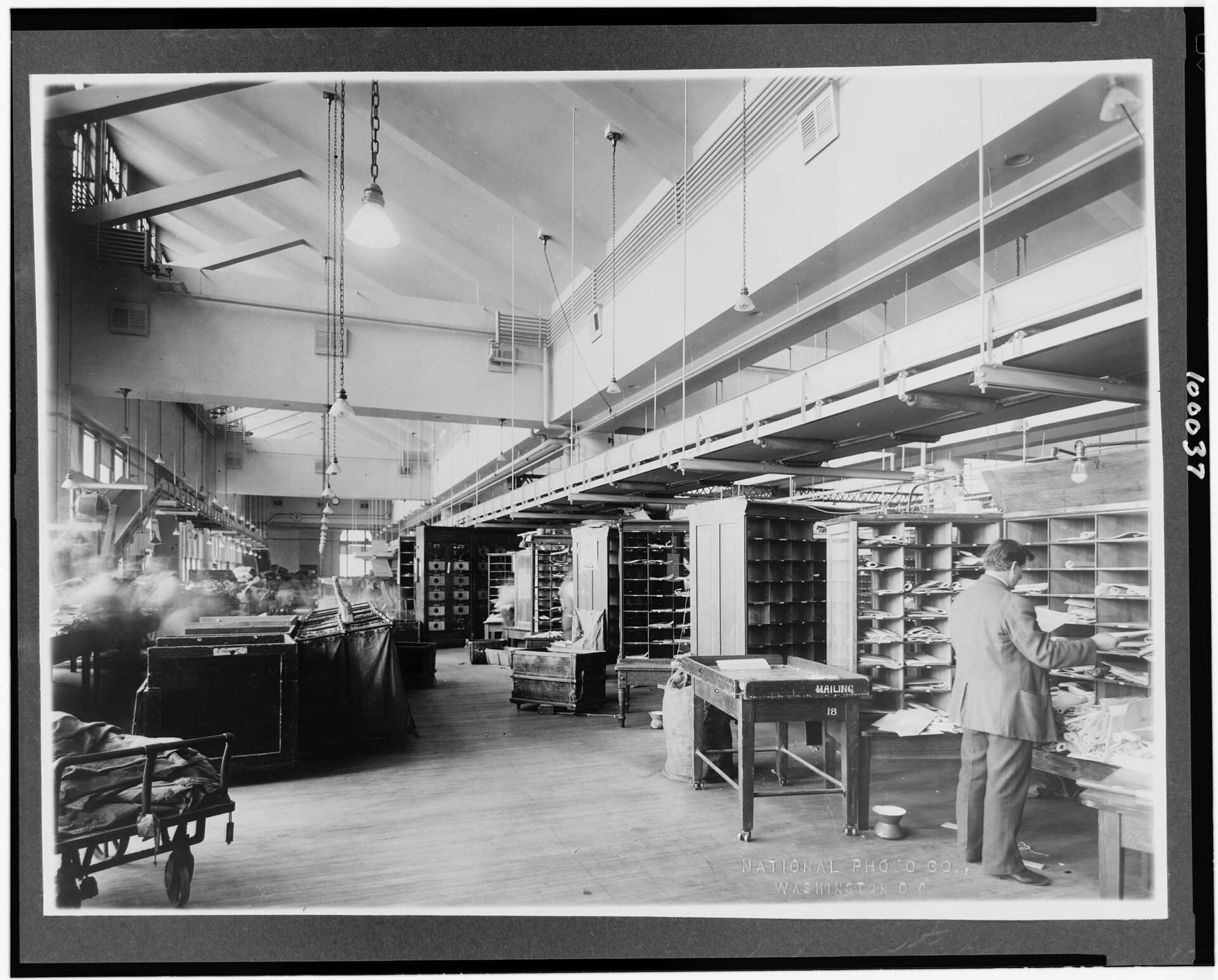 A post office mail sorting room in the 1920s, with pigeonhole racks and a sorting table