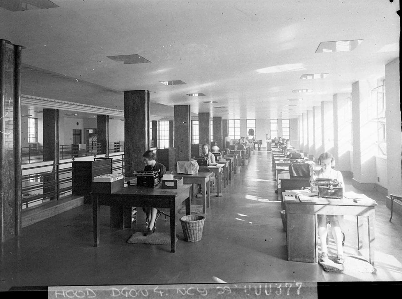 Typists at work at long rows of desks in an office in 1938